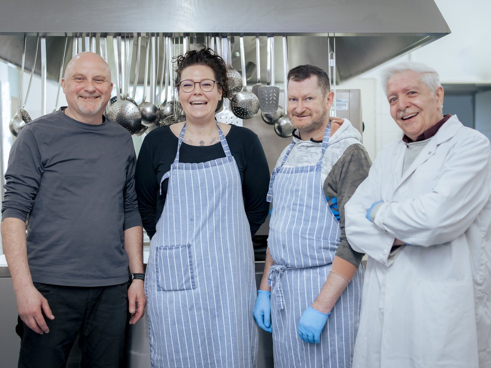 Küchenteam lacht in die Kamera